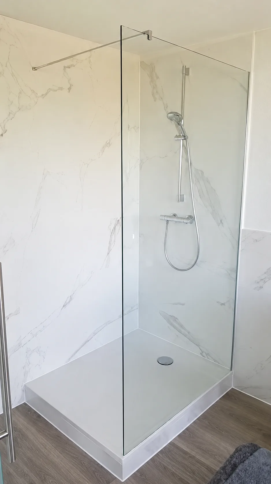 Freistehende Walk-in-Dusche aus Glas mit klarer Glaswand vor Wänden in Marmoroptik