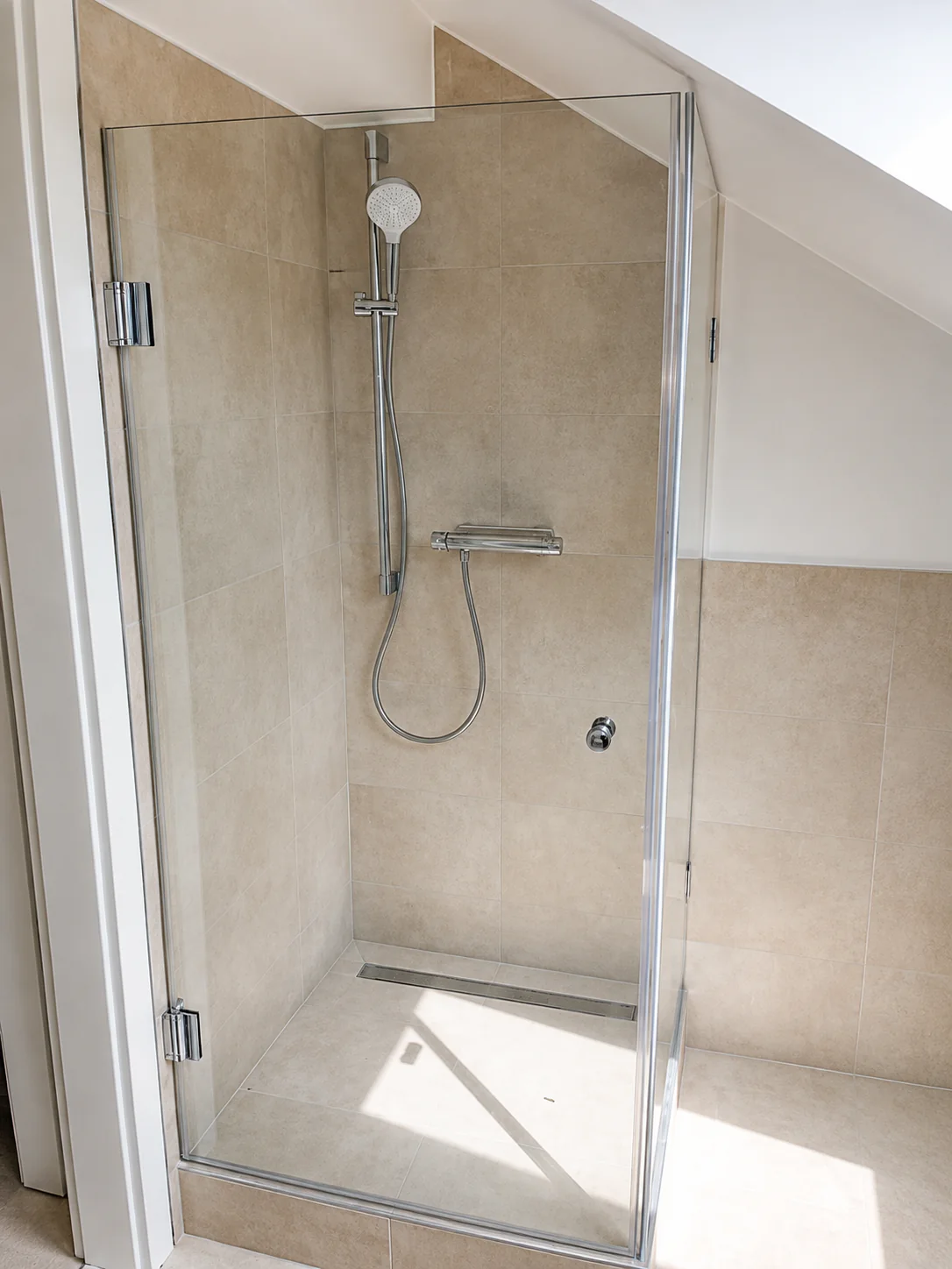 Maßgefertigte Glasdusche unter einer Dachschräge in einem Badezimmer in Hannover