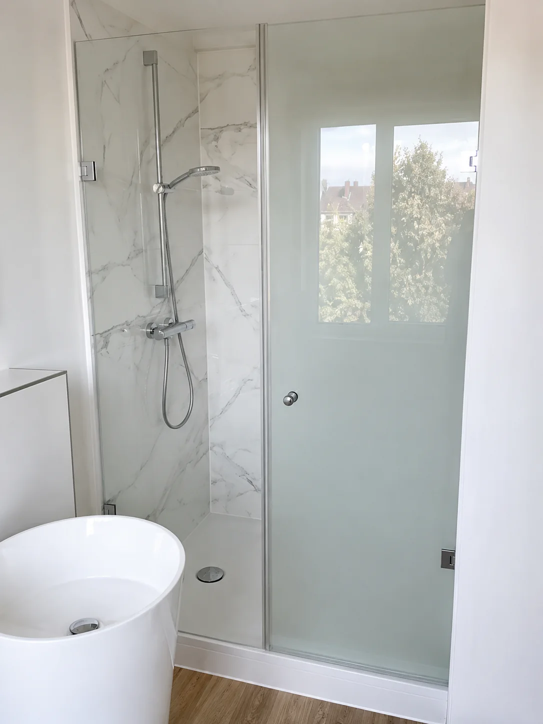 Nischendusche mit Pendeltür und Festteil, zweite Ansicht Nischendusche mit festem Seitenteil und geöffneter Duschtür aus Klarglas, zweite Ansicht